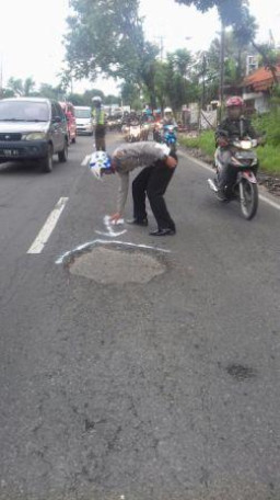 Prihatin Laka Lantas Tunggal, Lantas Polsek Pandaan Beri Tanda Jalan Berlubang Dengan Cat Putih.
